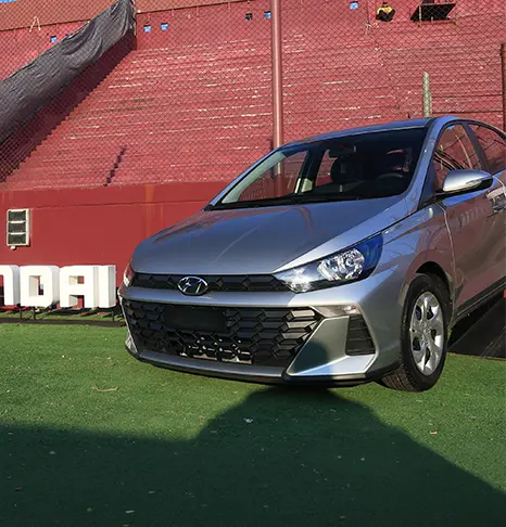 HB20 ao lado de placa da Hyundai dentro de um estádio de futebol. 