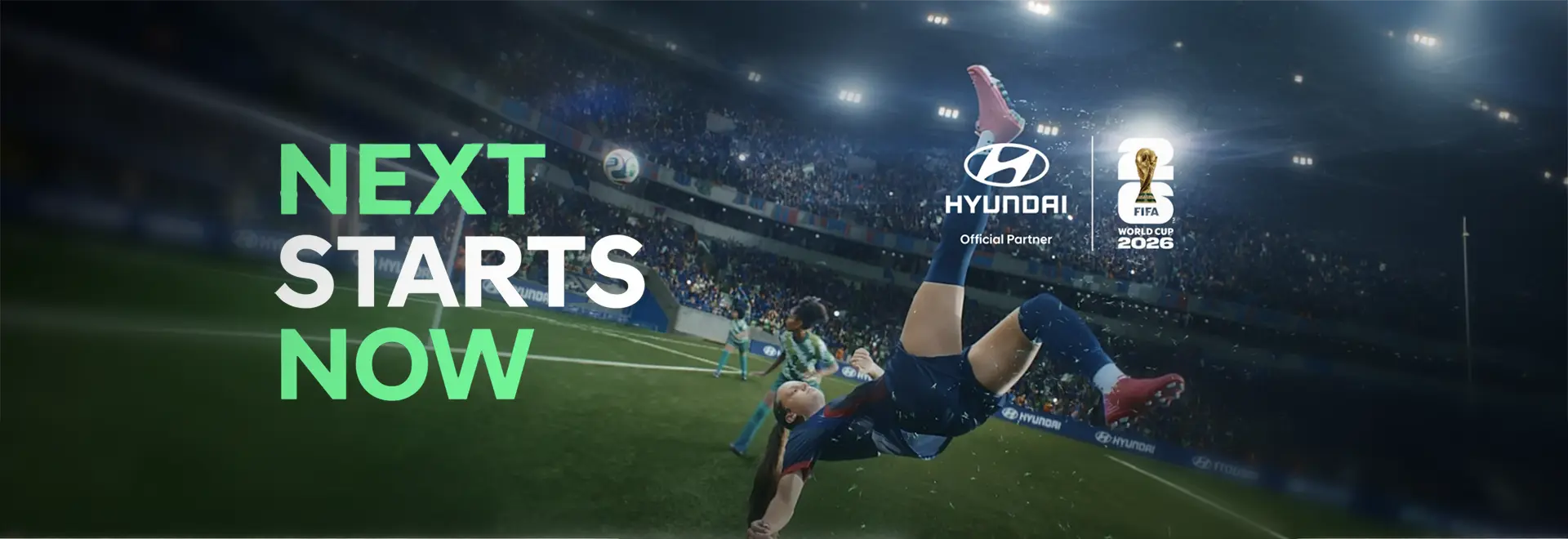 Jogadora de futebol fazendo um gol de bicicleta dentro de um campo. O texto diz: Next Starts Now. Na imagem, aparecem o Logo da Hyundai e da Copa do Mundo FIFA 2026™. 