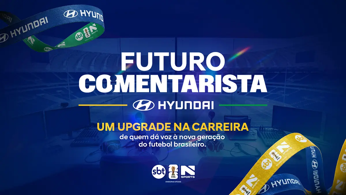 Cabine de comentaristas no estádio de futebol, fitas de pescoço personalizadas com logos do SBT, Copa do Mundo FIFA 2026™ e N Sports compondo arte em azul, verde e amarelo. O texto diz: “Futuro Comentarista Hyundai. Um upgrade na carreira de quem dá voz à nova geração do futebol brasileiro.”