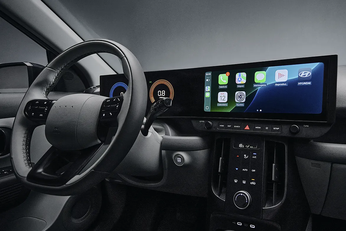 Interior do Novo Hyundai i20 com central multimídia ligada e painel de instrumentos digital aceso. 
