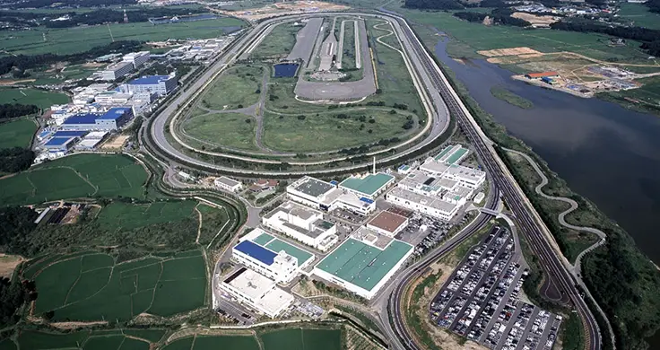 Centro de Pesquisas e Testes da Hyundai com pista de corrida e fábricas durante o dia.