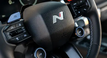 Volante de um carro com emblema N Line no centro e botões de comando na lateral.