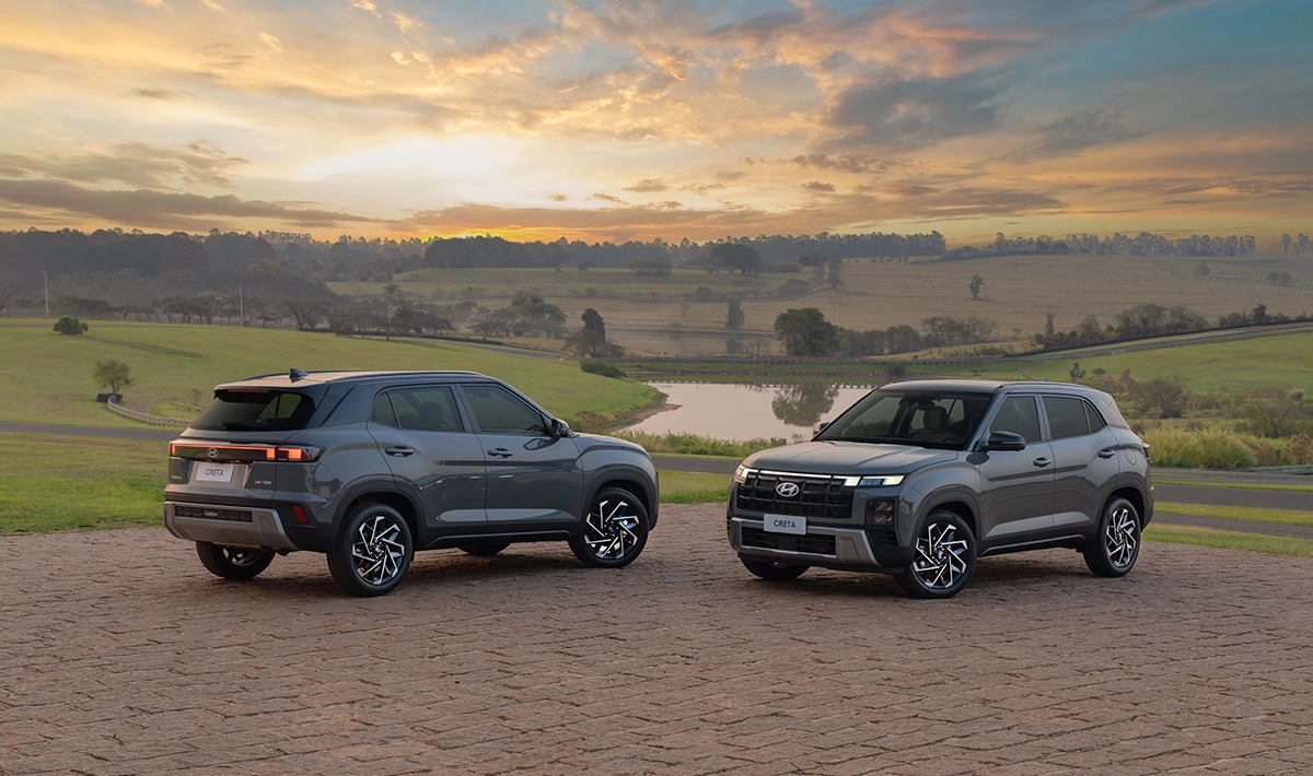 Dois modelos do Hyundai CRETA estacionados em uma estrada durante o dia com lagoa de fundo.