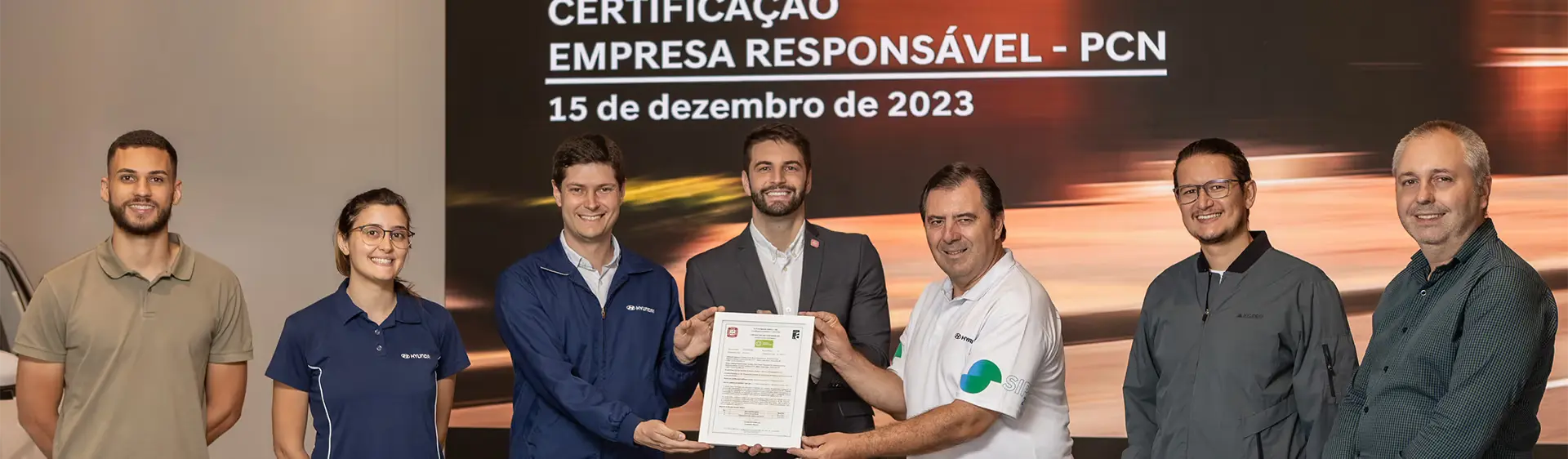 Representantes da Hyundai recebendo selo PCN INMETRO durante evento.