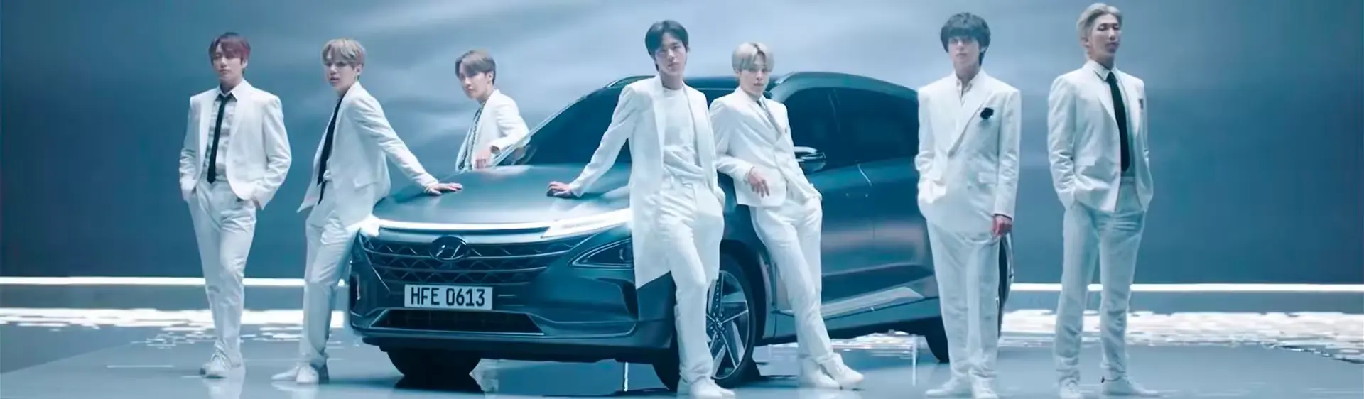 Cantores do grupo de K-Pop BTS em um estúdio ao lado do Hyundai NEXO.