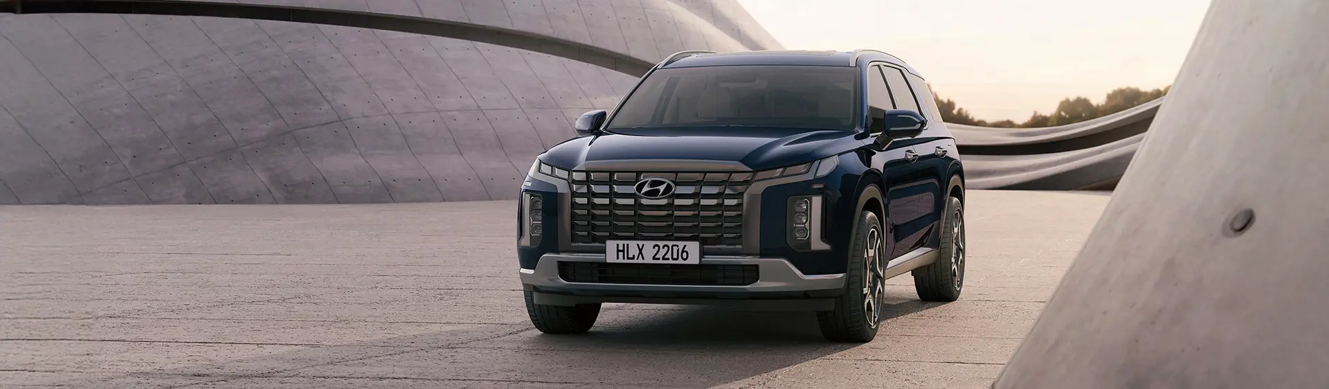 Modelo Hyundai PALISADE na cor azul estacionado durante o dia.